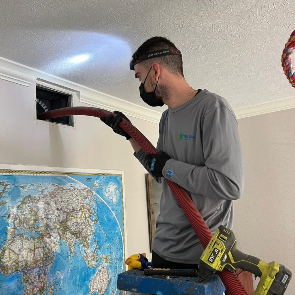 Technician brushing interior air duct during cleaning service
