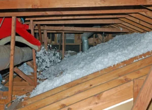 professional installing attic insulation to improve energy efficiency