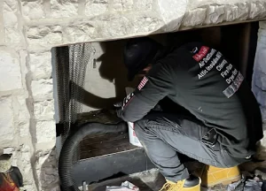 professional chimney sweep cleaning a chimney with specialized tools