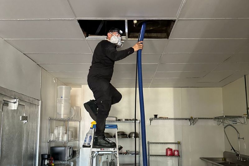 Top Star Air Pros performing an air duct cleaning at a restaurant