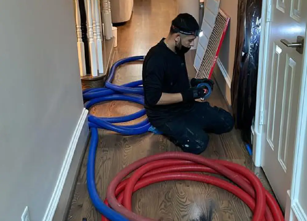 Workers cleaning air ducts in a residential home